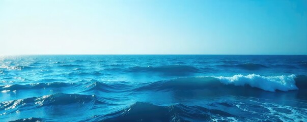 Fototapeta premium Vast expanse of deep blue ocean water, waves gently rolling under a clear sky Perfect for travel, nature, and serenity themes , oceanic, serenity