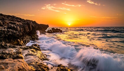 Dramatic sunset over ocean waves crashing on rocks