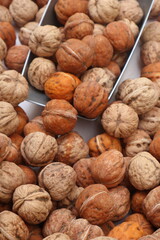 Walnuts in a bowl at the market with a scoop taking out walnuts, fresh nuts, healthy food