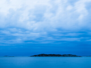 Bright blue waters surrounding a tranquil island near Gothenburg, Sweden during a cloudy day