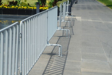 Light gray metal fences, barricades made of welded pipe with copy space on city street. Protruding...