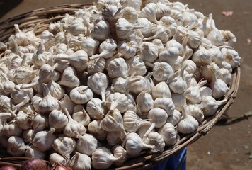 An image of garlic piled up in a basket for sale.