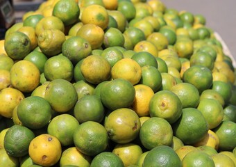 Sweet limes are piled up at the fruit market for sale.
