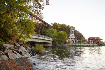 The Cap-Rouge river flowing into the St. Lawrence river under an overpass and 1908 railway trestle bridge during a fall morning, with the marina in the background, Quebec City, Quebec, Canada