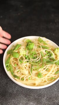 Spaghetti vegetables green peas, broccoli, string beans, kohlrabi vegetarian pasta tasty snack fresh delicious gourmet food background on the table rustic top view copy space vegan food