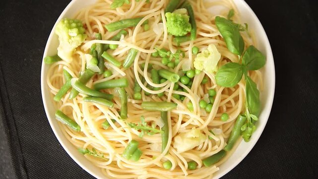 Spaghetti vegetables green peas, broccoli, string beans, kohlrabi vegetarian pasta tasty snack fresh delicious gourmet food background on the table rustic top view copy space vegan food