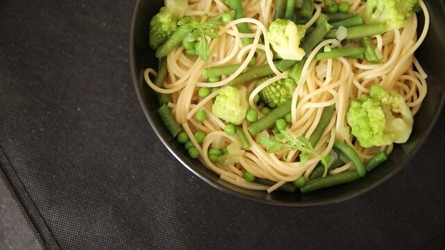 Spaghetti vegetables green peas, broccoli, string beans, kohlrabi vegetarian pasta tasty snack fresh delicious gourmet food background on the table rustic top view copy space vegan food