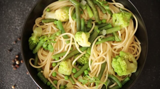 Spaghetti vegetables green peas, broccoli, string beans, kohlrabi vegetarian pasta tasty snack fresh delicious gourmet food background on the table rustic top view copy space vegan food