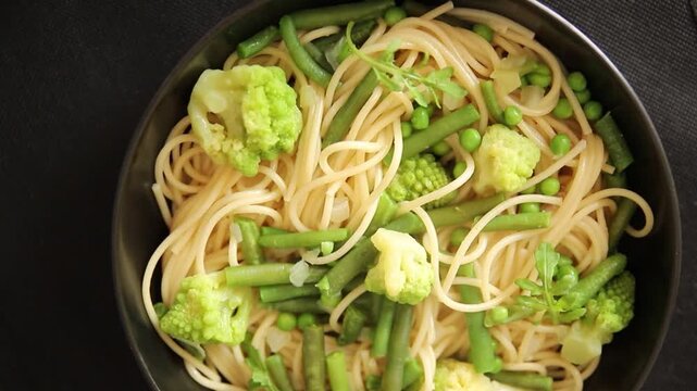 Spaghetti vegetables green peas, broccoli, string beans, kohlrabi vegetarian pasta tasty snack fresh delicious gourmet food background on the table rustic top view copy space vegan food