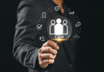 Businessman holding magnifying glass focusing on CRM, representing customer relationship management, business strategy, data analysis, marketing automation and client retention concept.