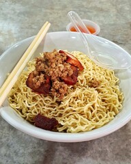 Sarawak Kolo Mee, famous noodle dish from Sarawak, Malaysia, featuring minced pork, char siu and noodles, often enjoyed in hawker centers and coffee shops.