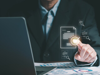 A businessman is pointing to a digital overlay of a document with a checkmark, symbolizing the concepts of document verification, approval process, and digital security. Paperless office solutions.