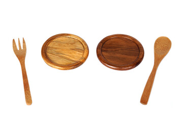 A set of eco-friendly wooden utensils featuring a fork, spoon, and round plates, perfect for rustic dining, food styling, or sustainable kitchen concepts with natural texture and charm.