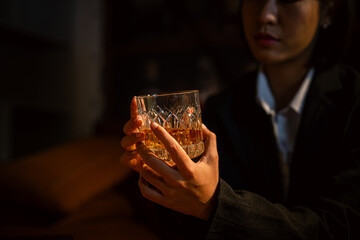 Closeup business woman holding a glass of whiskey