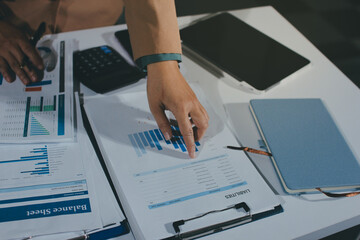 Close-up of businessman's hands making notes, mobiles, chart, desk, office