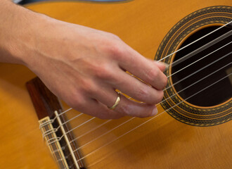 Female human hand playing an accoustic guitar  strumming the strings