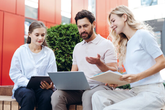 Diverse team collaborating outdoor business meeting discussion