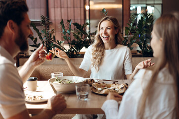 Friends enjoying meal and conversation at a modern restaurant