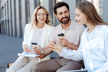 Business people discussing project outdoors during coffee break