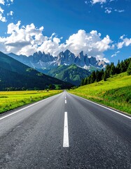Fototapeta premium Scenic mountain road stretching into the distance under a vibrant blue sky