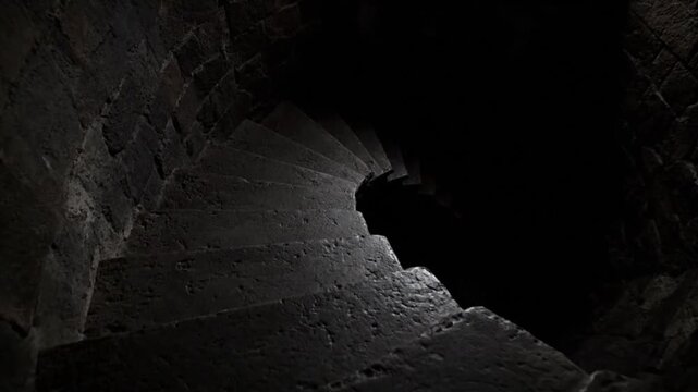 Ancient Dark Stone Spiral Staircase Descending into Deep Shadows Mysterious Medieval Castle Dungeon Steps Rough Textured Winding Path to Unknown Depths