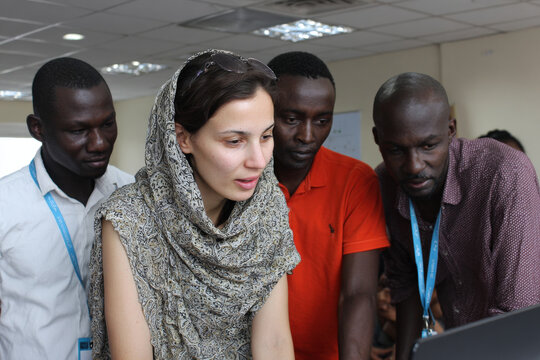 diverse group of migrants receiving assistance from ai program designed to help them acclimate to their new