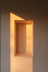 Minimal architectural niche illuminated by warm sunlight and cinematic tones