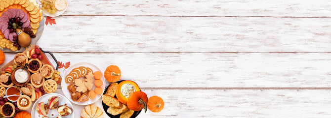Thanksgiving appetizers, sweets and grazing boards. Top view corner border on a white wood banner background. Pumpkin and apple snacks, pies, turkey cheese platter, desserts.