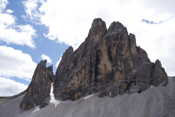 Majestic Tre Cime mountain peaks under a cloudy sky showcasing stunning natural rock formations and rugged terrain