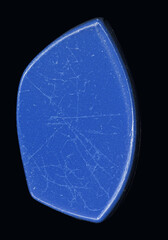 scan of a single irregularly shaped blue plastic piece with visible scratches and wear, isolated on black background.