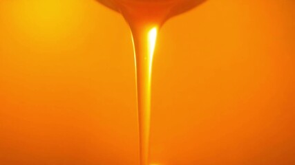 Golden Syrup Dripping - A close-up macro shot of thick, rich, liquid gold syrup slowly cascading down against a warm, illuminated amber background, showcasing its viscous texture and sweet - Powered by Adobe