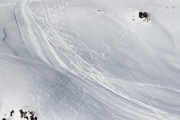 Snow off-piste slope with traces of skis and snowboards