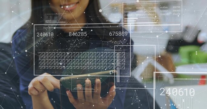Holding smartphone tapping keyboard grid at office desk in dark blouse, with holographic panels