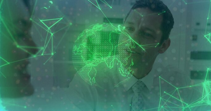 Studying colleagues in suits viewing holographic globe with network nodes and triangles in office