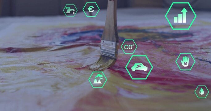 Fototapeta Paintbrush with wood handle applying red paint on canvas in art studio, with green hexagon icons