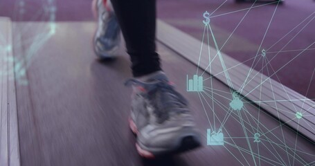 Moving legs wearing running shoes on treadmill belt at gym, with digital overlay of financial icons