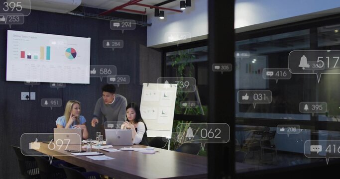 Reviewing professionals analyzing sales on laptops in meeting room, with display charts, flipchart