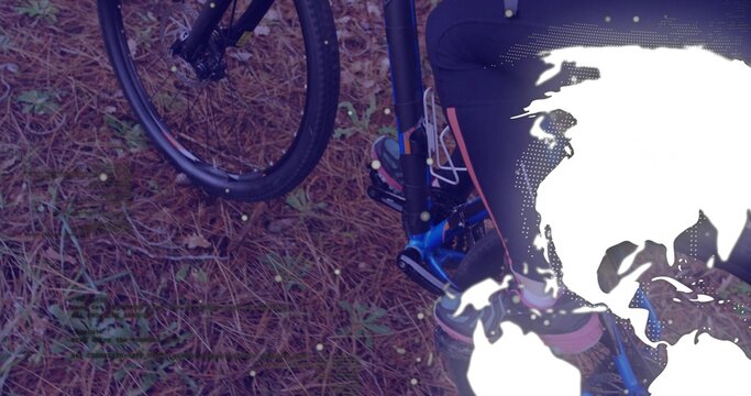 Fototapeta Showing lower body standing beside bicycle front wheel on forest floor, with world map overlay