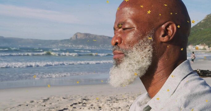 Sitting elderly man wearing light gray shirt on shoreline, with gold star overlays, copy space - Powered by Adobe