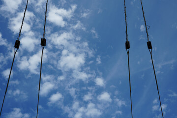 Obraz premium Wire ropes and pulleys against a blue sky with clouds on the East Midlands Airport Trail Nottinghamshire England outdoor scene