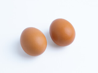 Two brown eggs on clean white background, perfect for themes of healthy eating, baking, protein, Easter, food, minimalism, nutrition, and simple design.