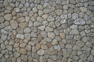 grey stone wall texture with natural round rocks – seamless background