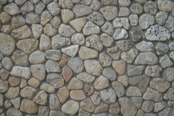 grey stone wall texture with natural round rocks – seamless background