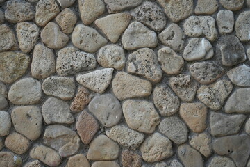 grey stone wall texture with natural round rocks – seamless background