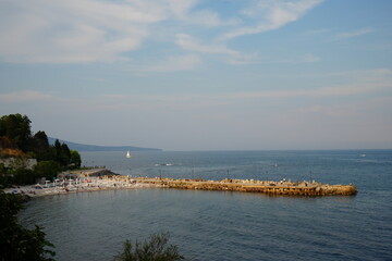 Stone breakwater in calm sea near Nessebar, Bulgaria. Blue water and sky creating peaceful coastal landscape with minimal composition.