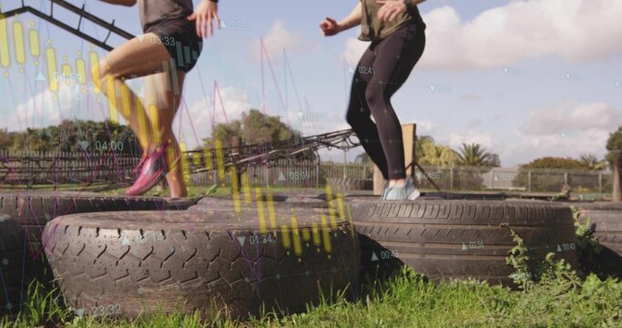 Two mid-adult women stepping on tires in sportswear on grassy field, with translucent data overlay