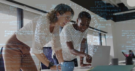 Women coworkers reviewing code on laptop in modern office with coffee mugs, pencil holder, notebook
