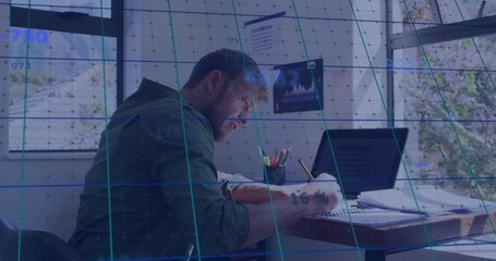Writing man jotting notes in notebook at desk by windows, with laptop, papers and AR overlay