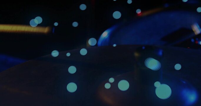 Shining metallic drum cymbal reflecting blue bokeh lights at rehearsal area, acoustic guitar body