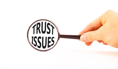 Trust issues symbol. Concept word Trust issues on beautiful magnifying glass. Businessman's hand....